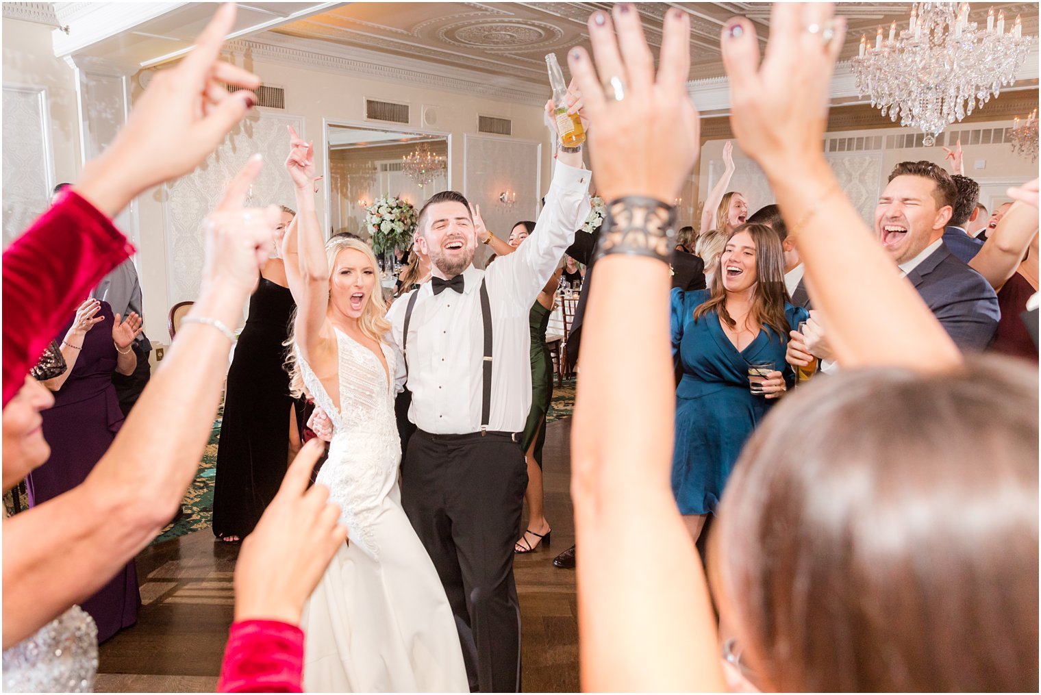 newlyweds cheer during Red Bank NJ wedding reception dancing with guests 