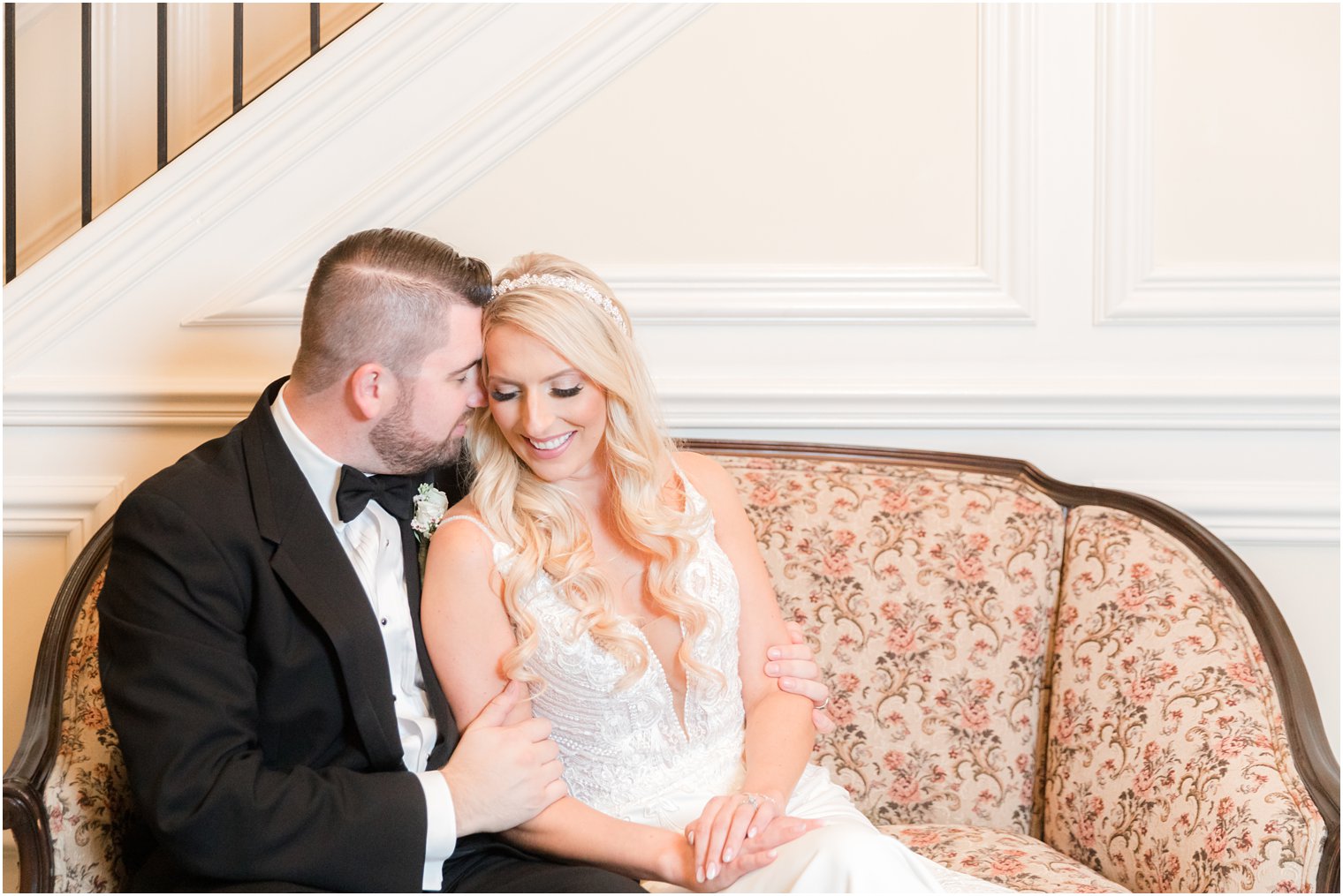 bride and groom sit together on vintage sofa at the Molly Pitcher Inn