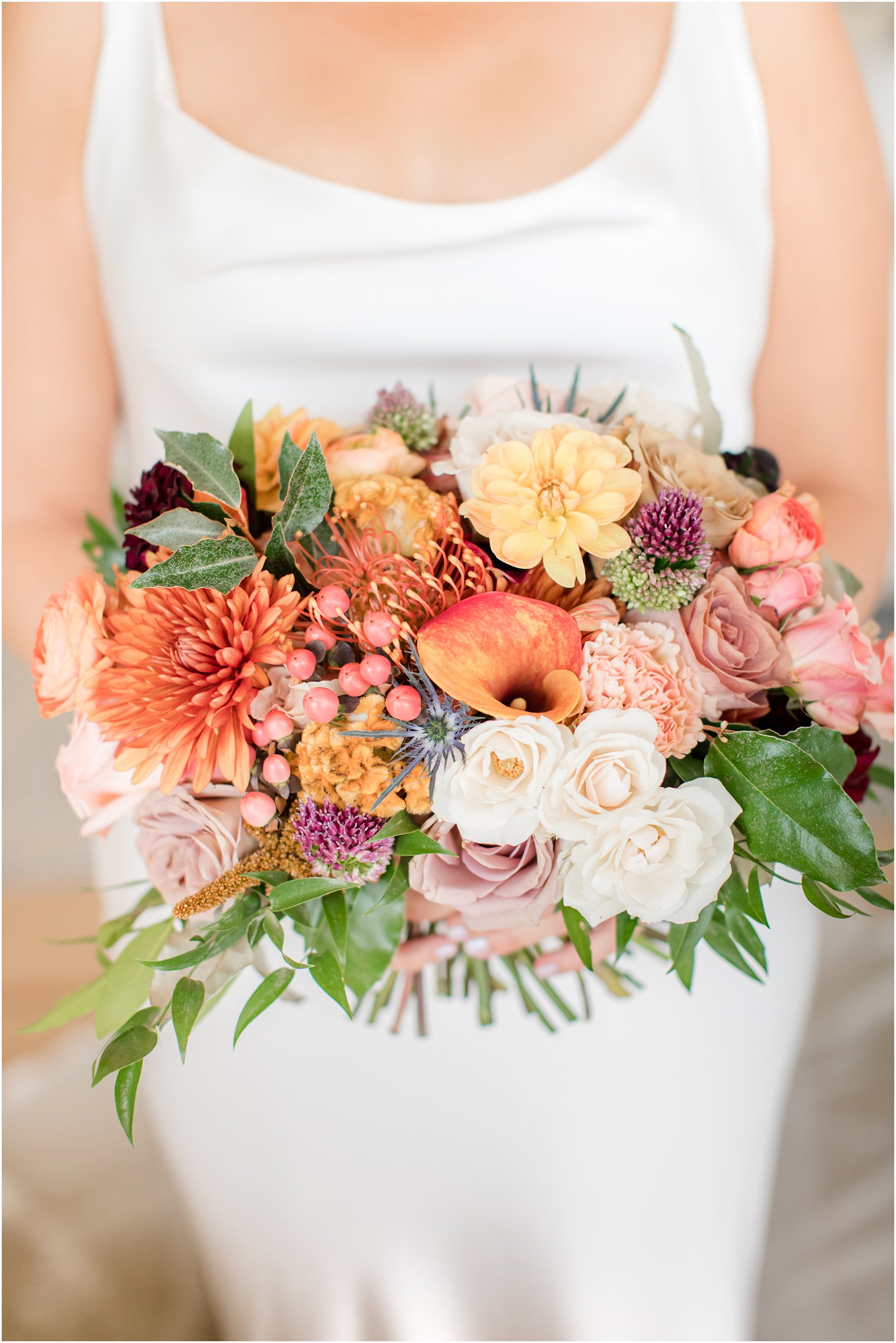 bride holds fall bouquet with orange lilies and white flowers for Bonnet Island Estate wedding