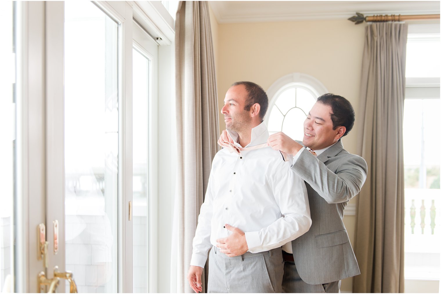 groomsman helps groom with tie during NJ wedding day