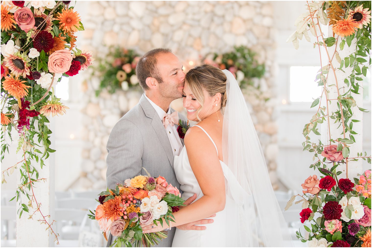 groom kisses bride's forehead during Bonnet Island Estate wedding portraits 