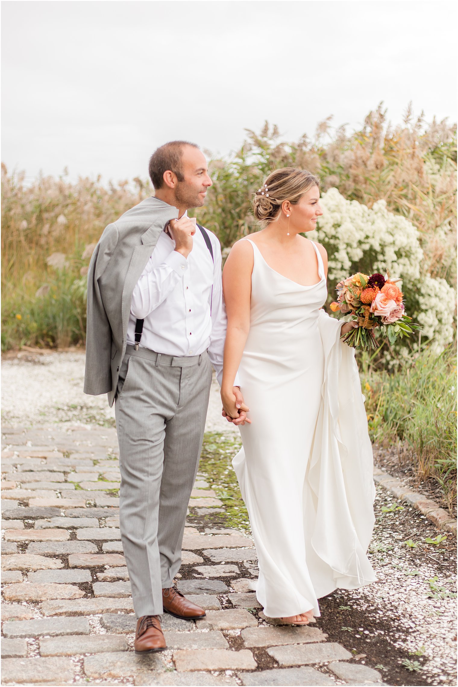 bride and groom look over the water during NJ wedding portraits 