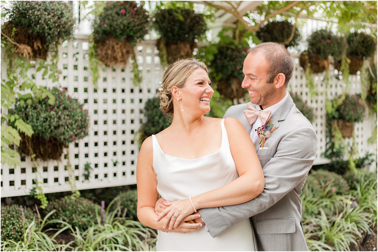 bride and groom smile together by planted plants at Bonnet Island Estate
