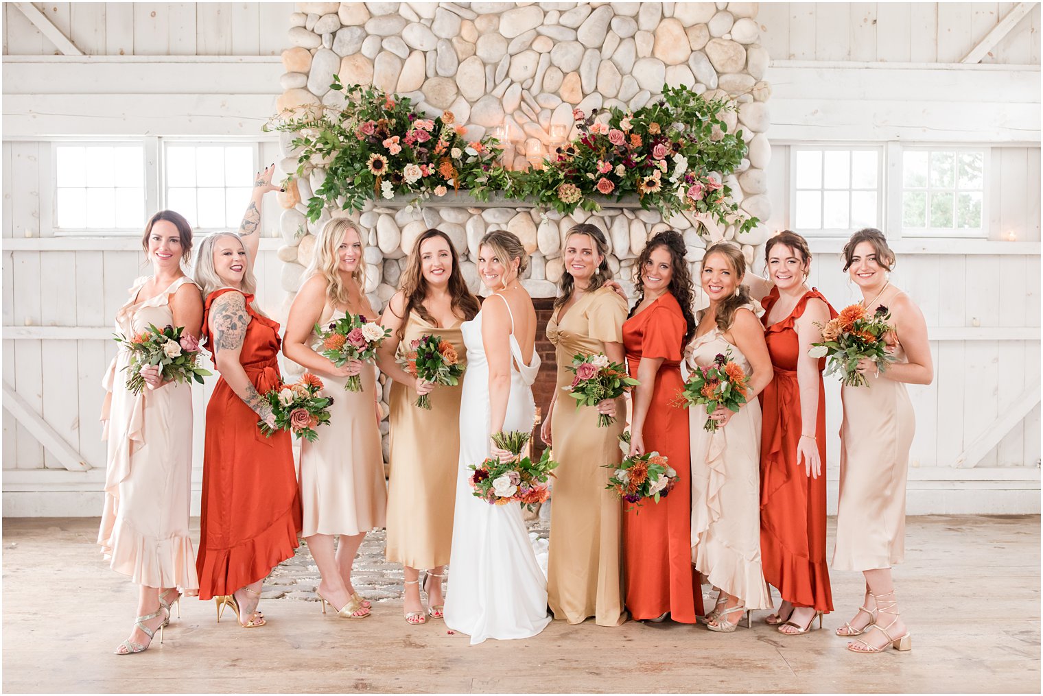 bride poses with bridesmaids in mismatched fall dresses at Bonnet Island Estate