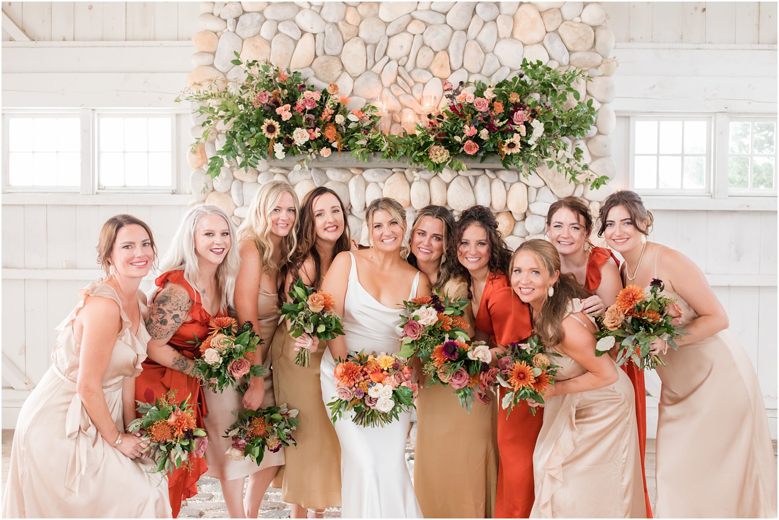 bride and bridesmaids hug together by fireplace at Bonnet Island Estate