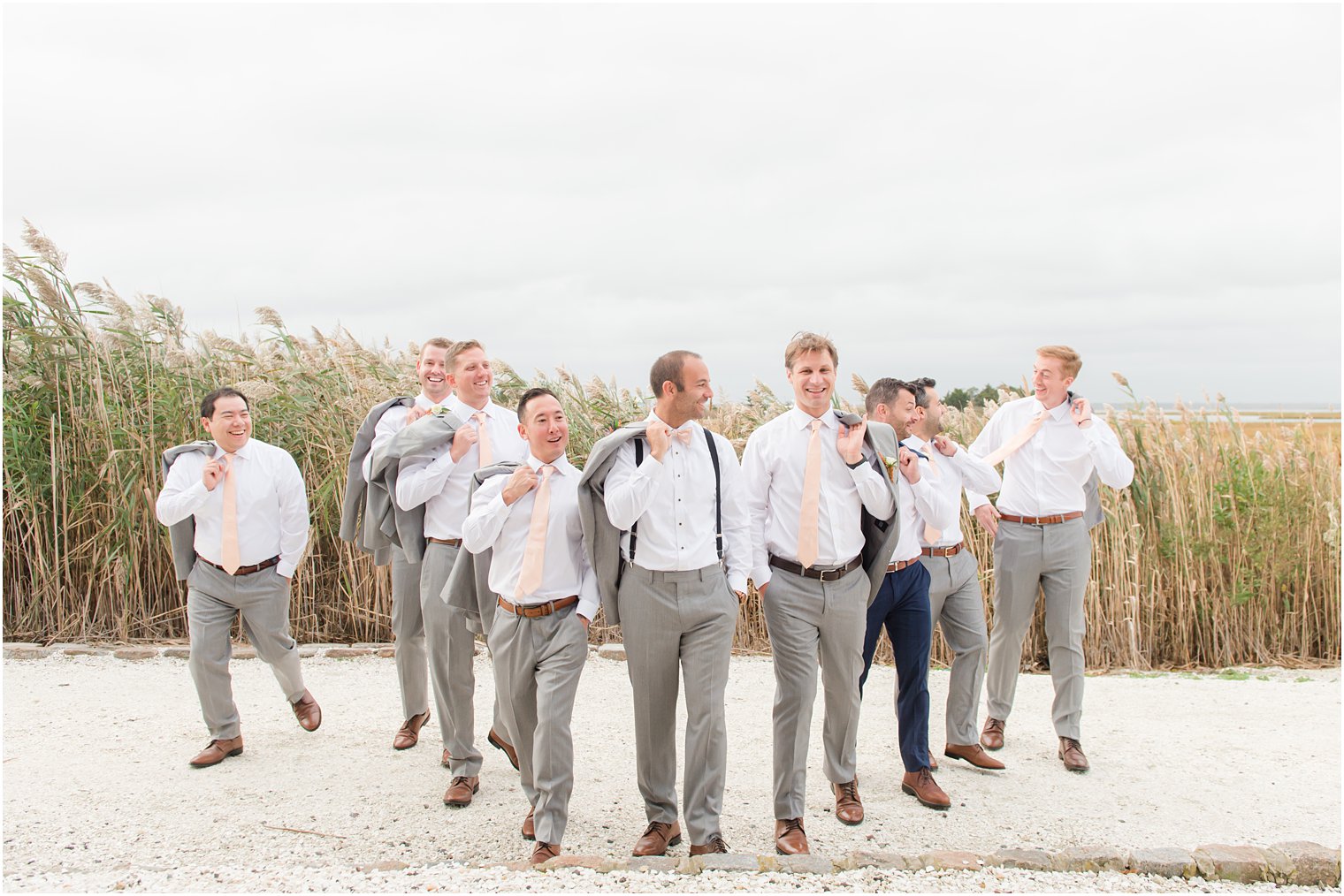 groom walks with groomsmen on beach before Bonnet Island Estate wedding