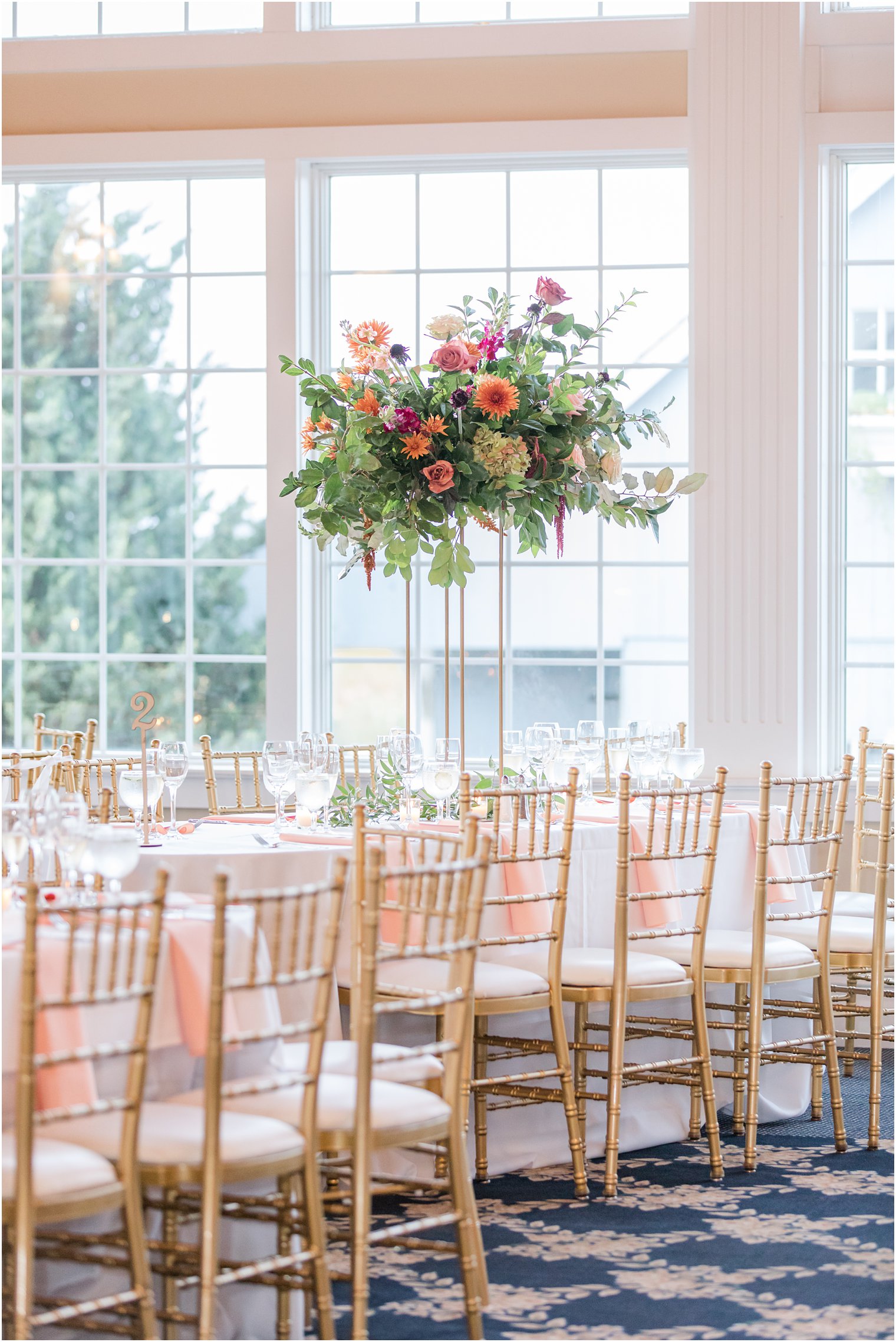 tall wedding reception centerpieces with colorful flowers at Bonnet Island Estate