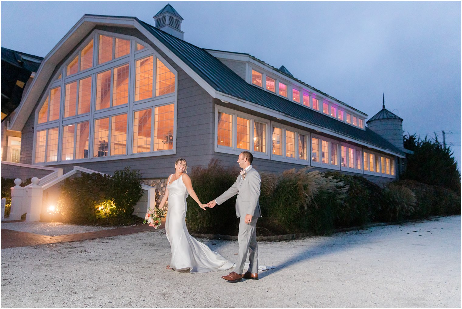 bride and groom hold hands outside at Bonnet Island Estate at nighttime 