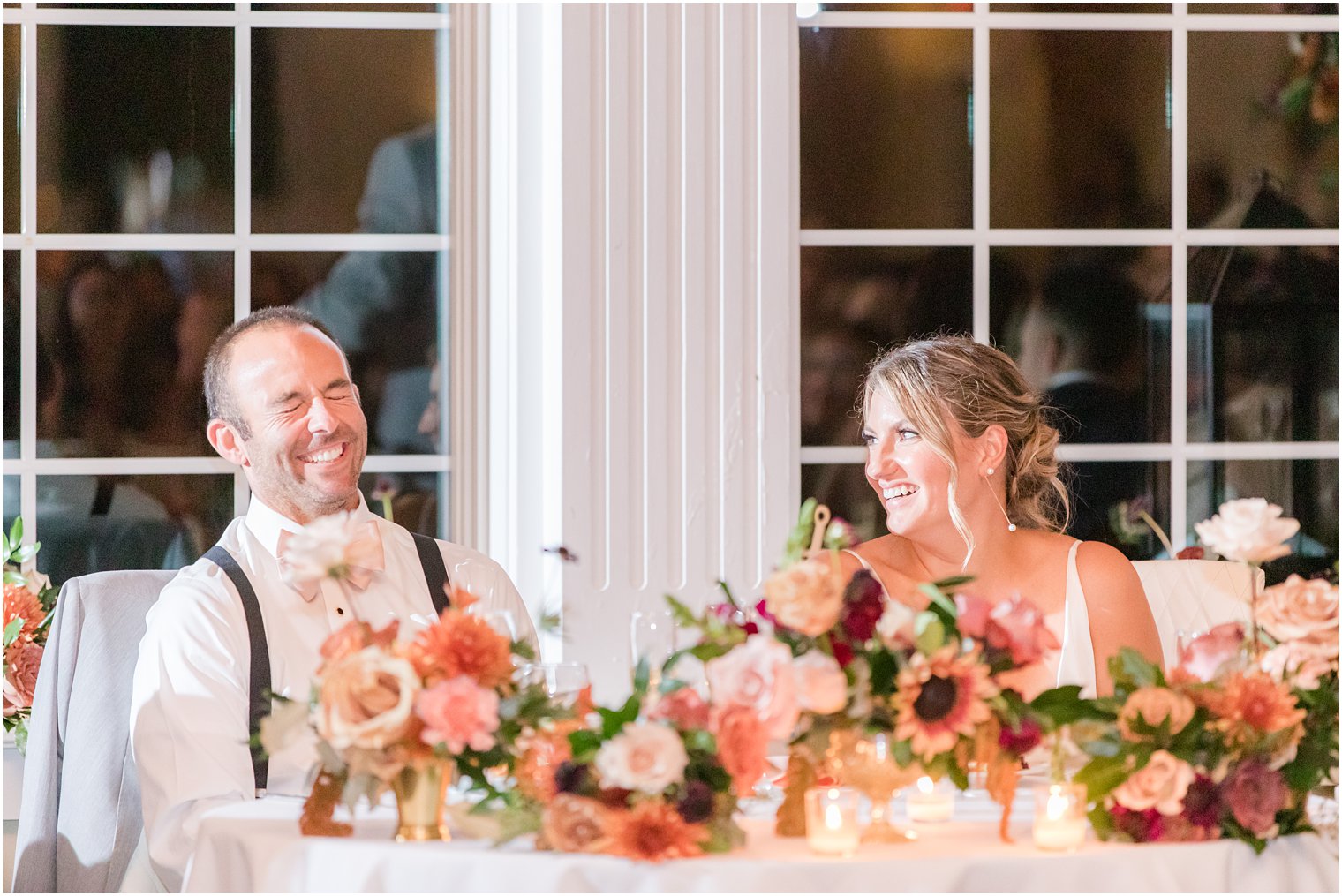 bride and groom laugh together during NJ wedding reception speeches