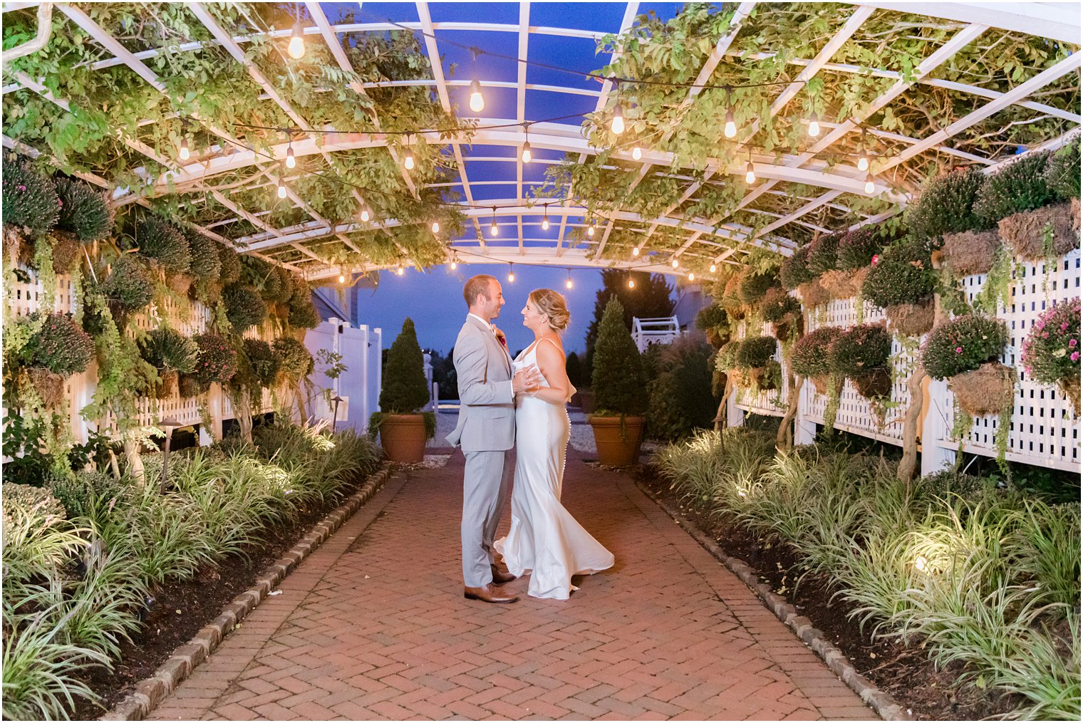 couple dances under bistro lights in gardens at Bonnet Island Estate