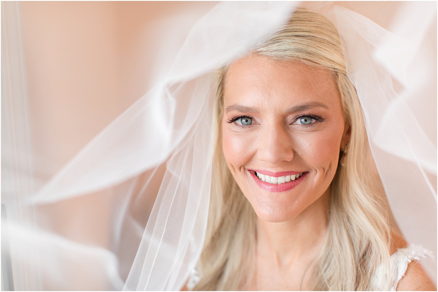 bride smiles with veil over her head before NJ wedding 