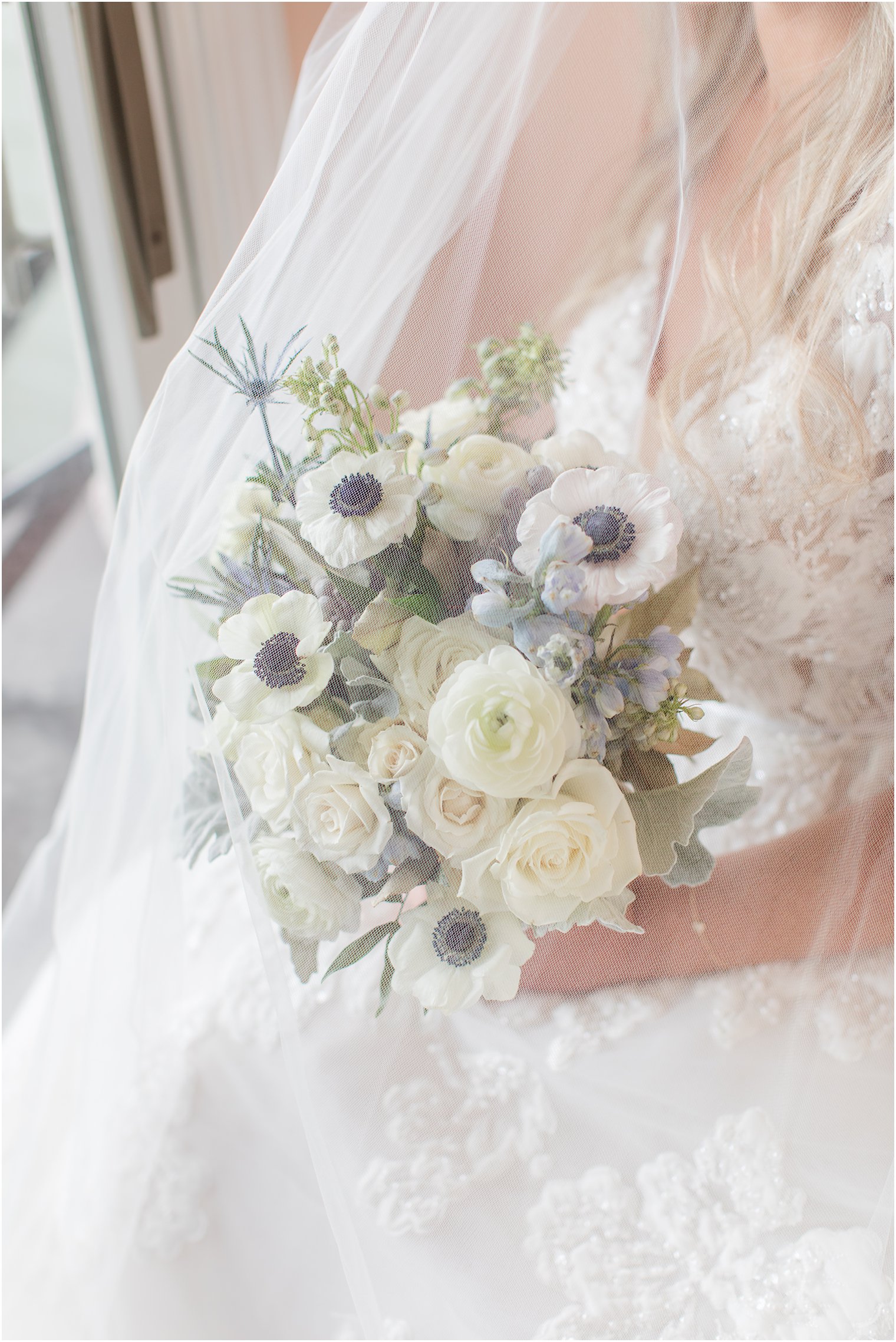 bride holds bouquet of white roses under veil at Brant Beach Yacht Club