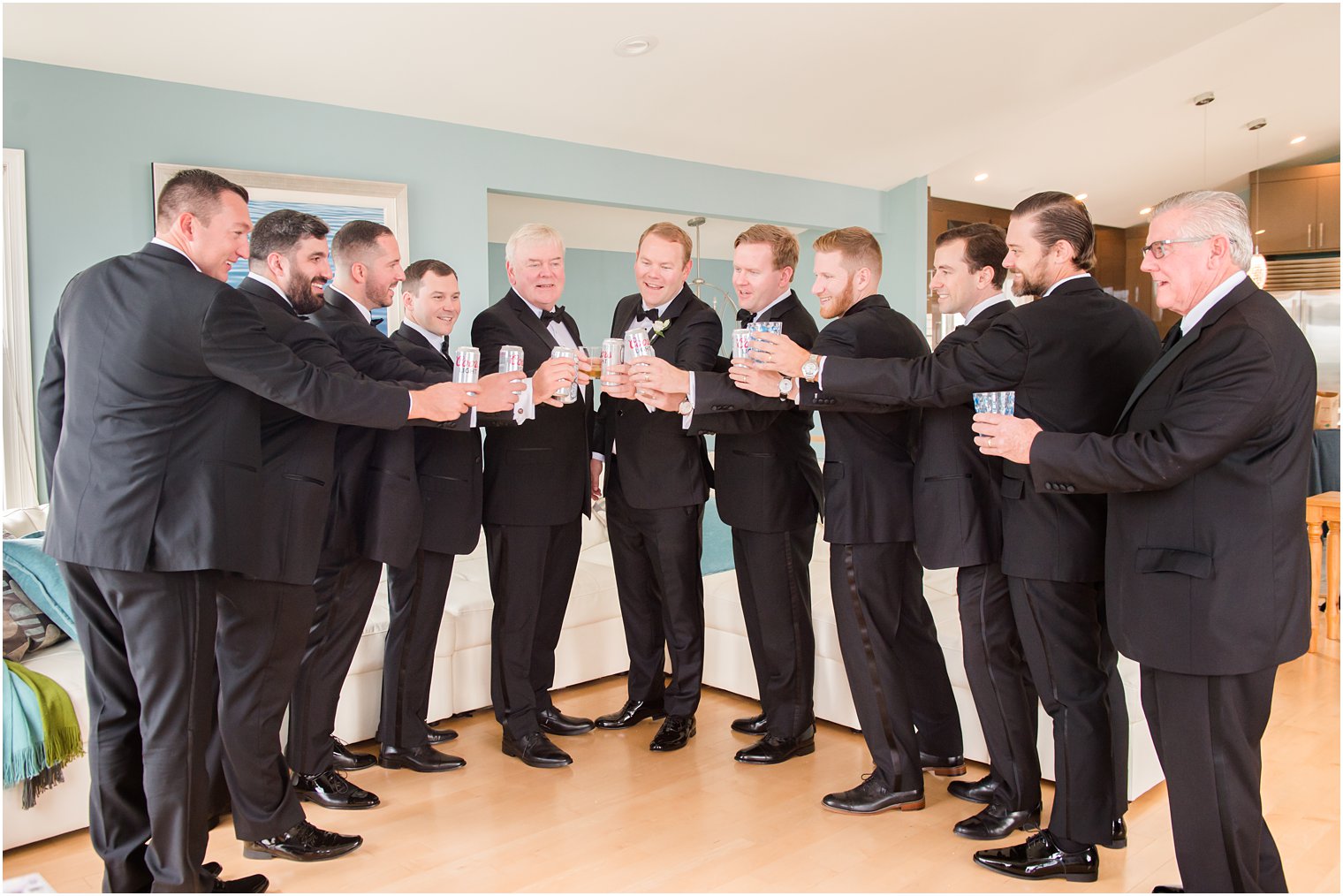 groom and groomsmen toast with beers at Brant Beach Yacht Club