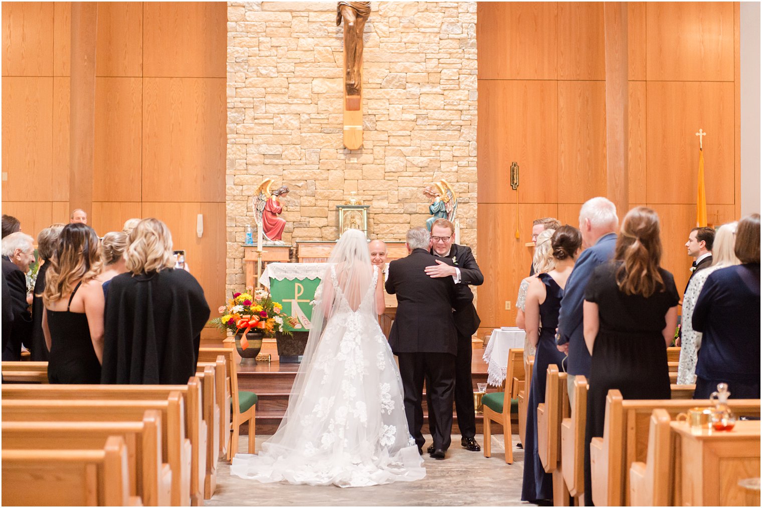 groom hugs bride's dad during traditional church wedding in New Jersey