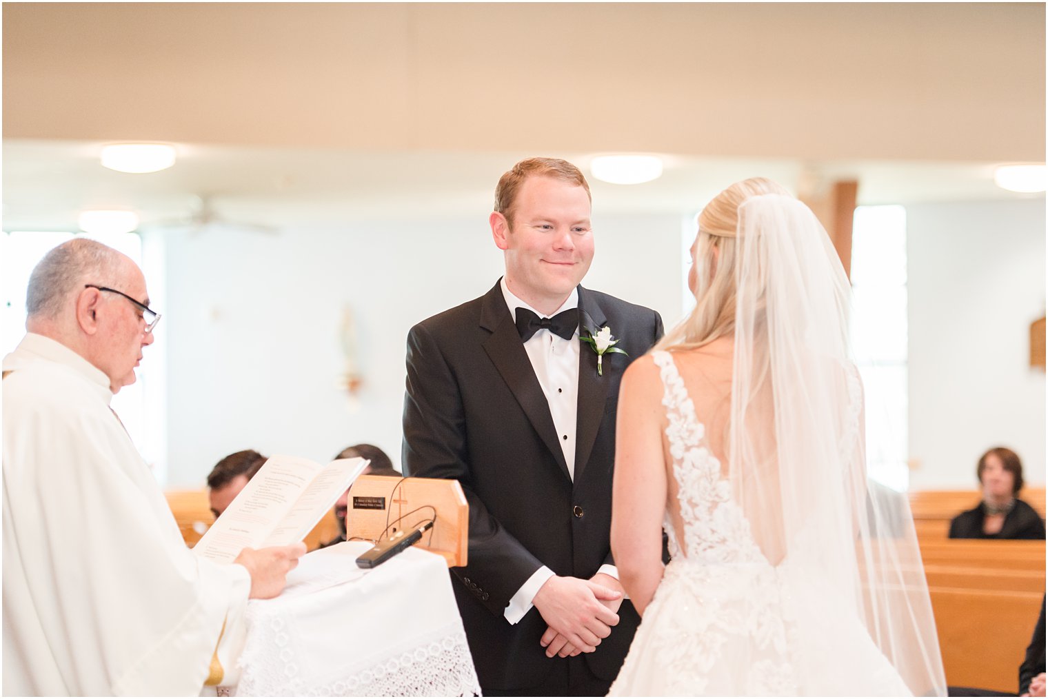 groom smiles at bride during traditional church wedding in New Jersey