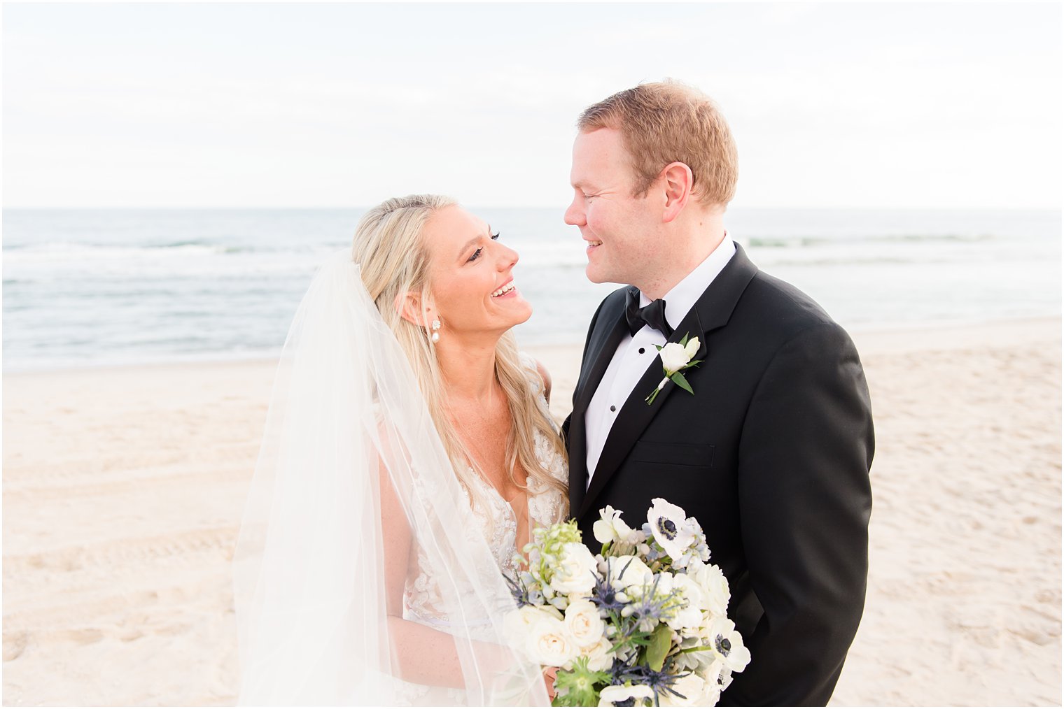 bride and groom smile at each other at Brant Beach in New Jersey 