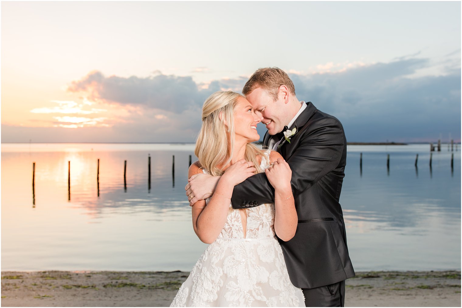 groom nuzzles bride's nose during beach wedding portraits in Long Beach NJ