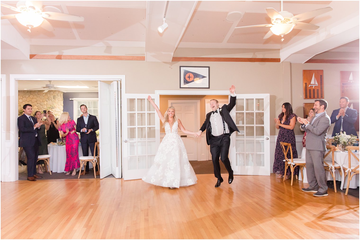 newlyweds cheer walking into wedding reception in New Jersey 