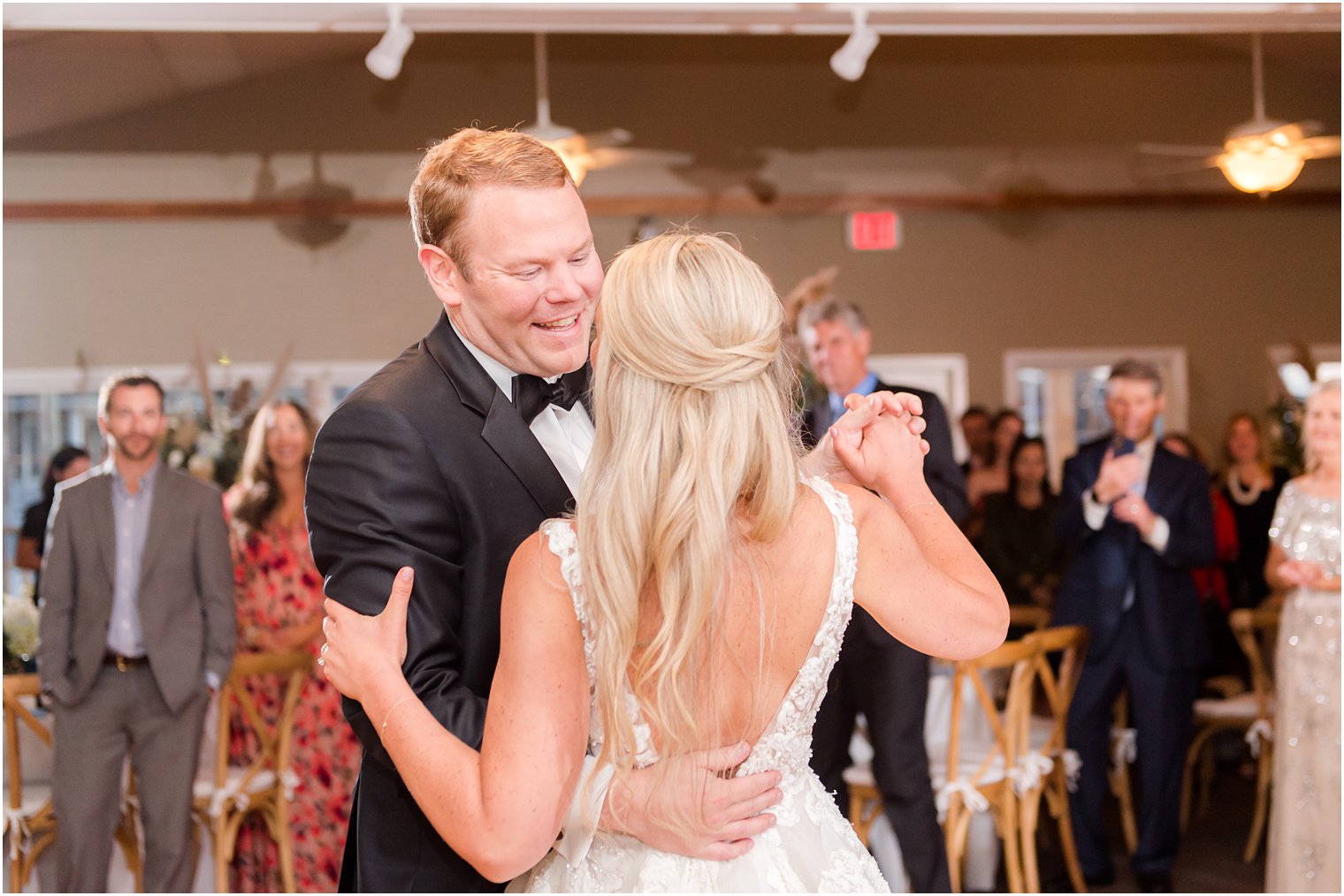 groom smiles at bride during first dance at Brant Beach Yacht Club