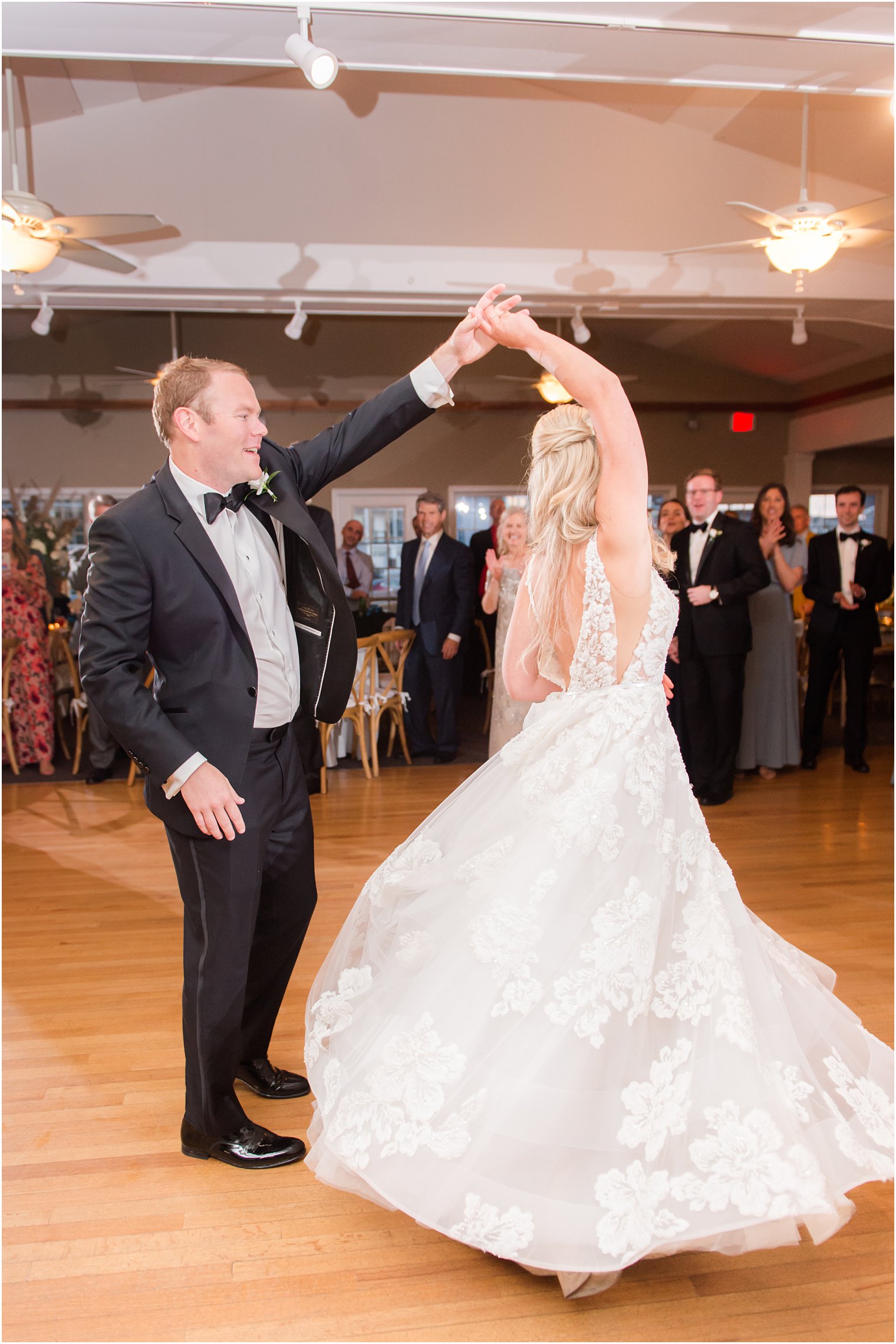 groom twirls bride during first dance at Brant Beach Yacht Club