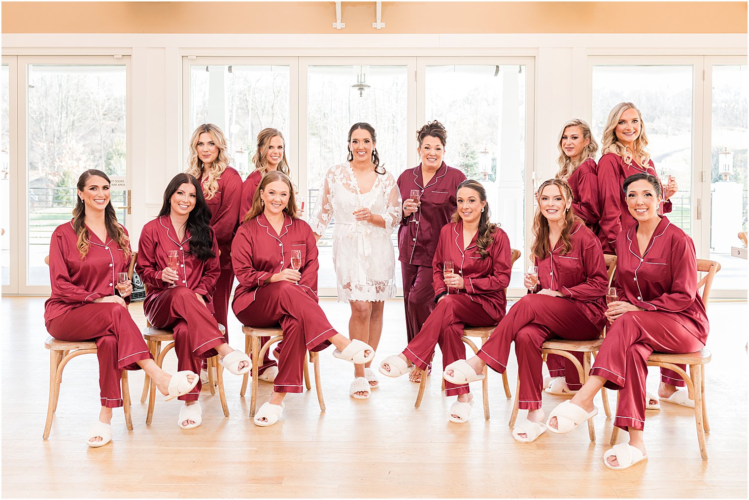 bridesmaids in red robes sit with bride before Bear Brook Valley wedding