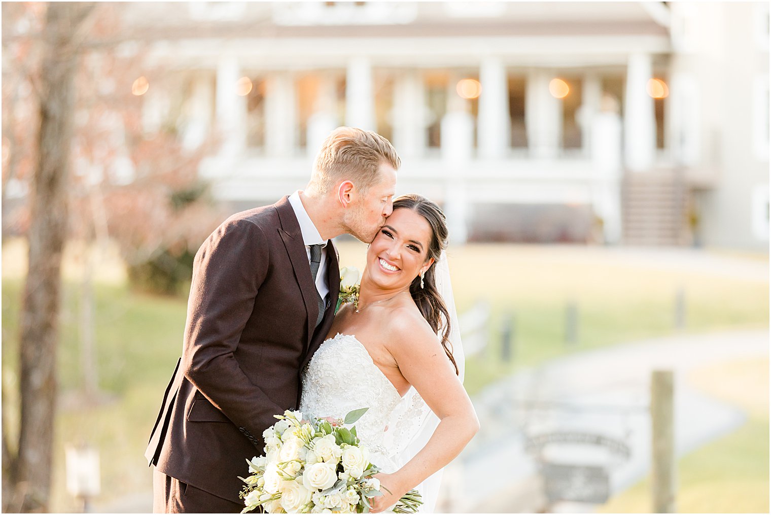 groom kisses bride's cheek during NJ wedding portraits 