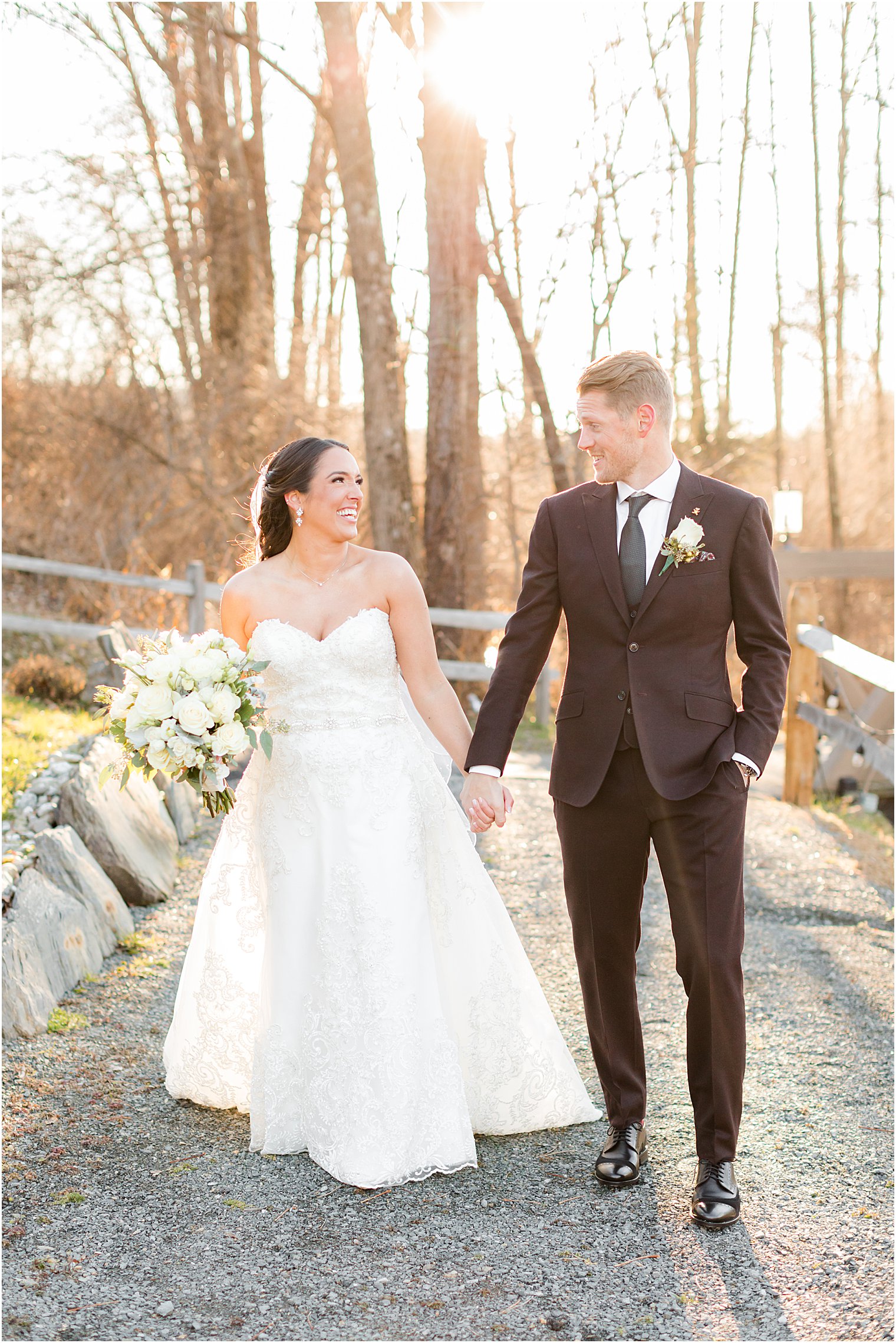 newlyweds walk together along path at Bear Brook Valley