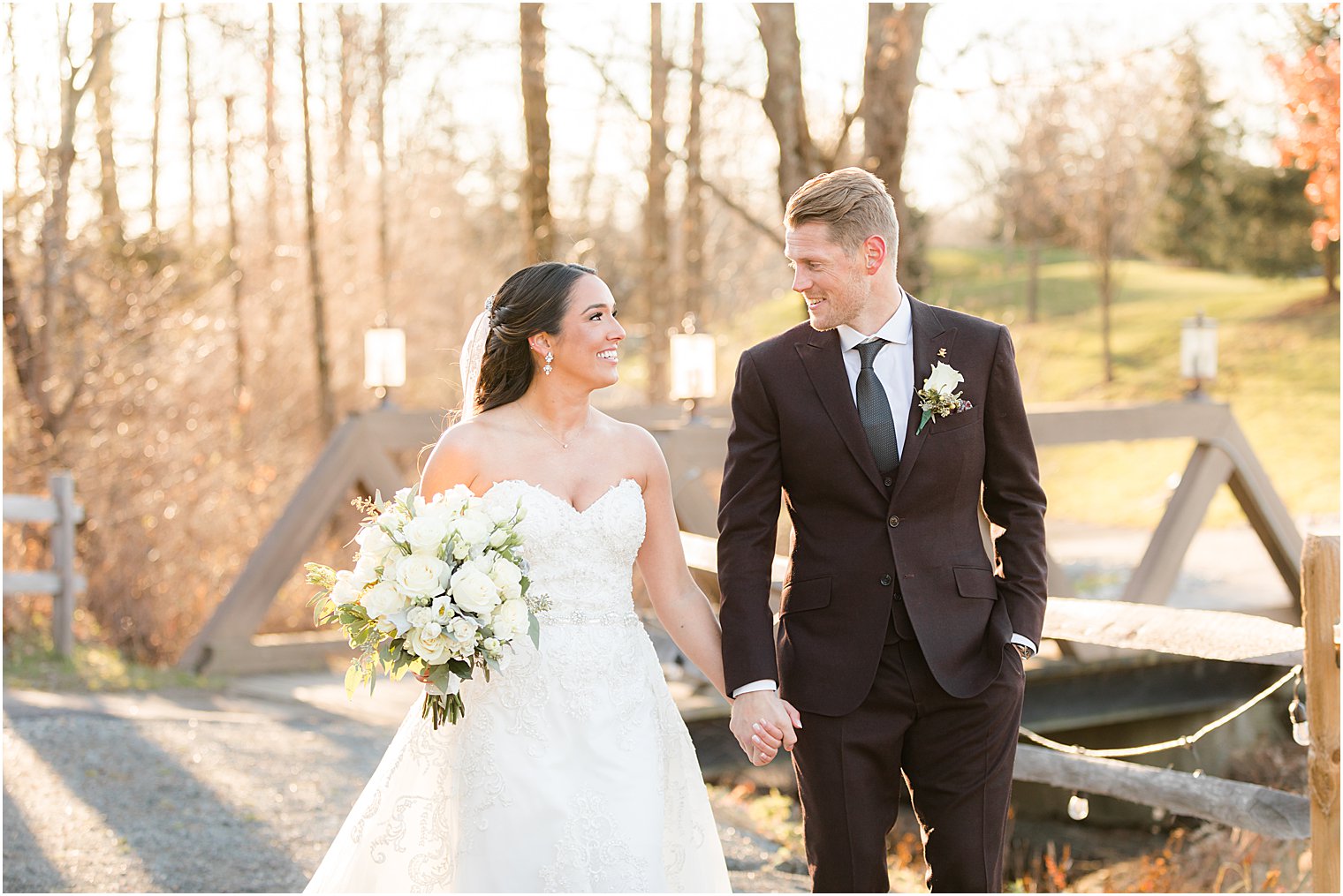 bride and groom smile near wooden bridge at Bear Brook Valley