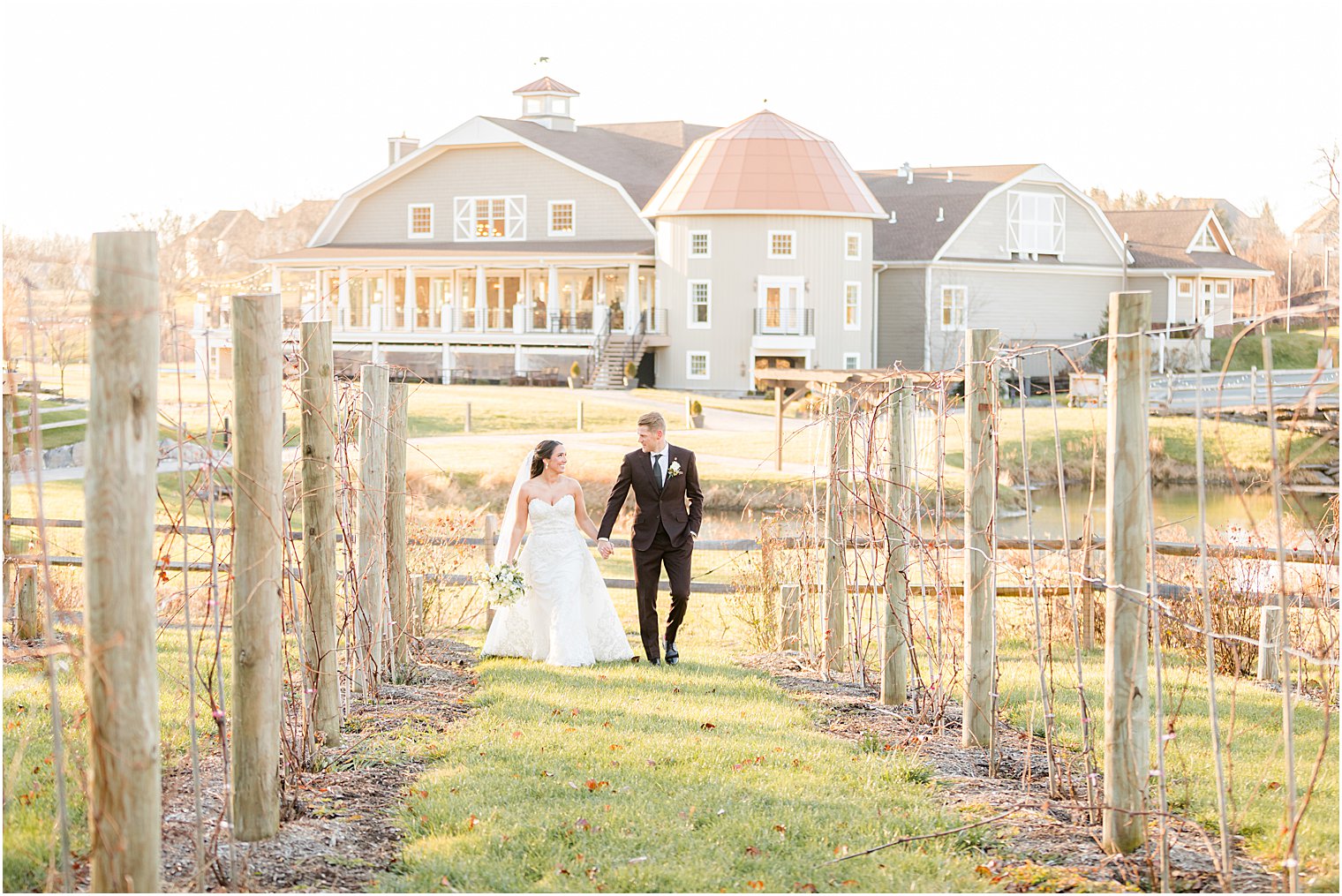 bride and groom walk through vines at Bear Brook Valley