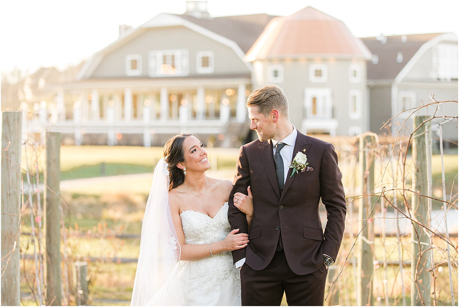 bride holds groom's arm looking up at him during Bear Brook Valley wedding portraits 