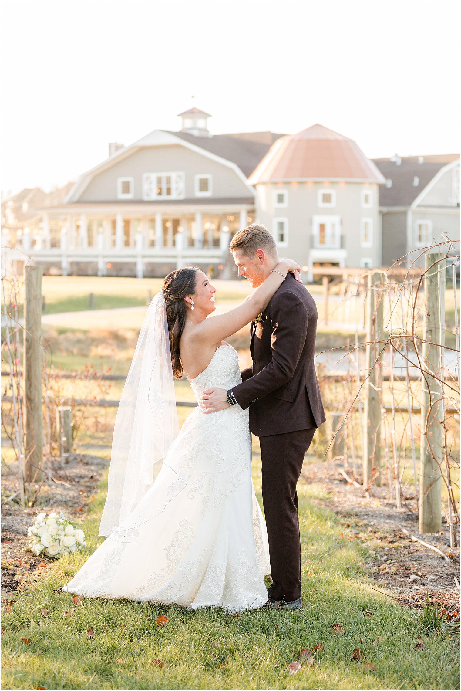 bride hugs groom around neck during wedding portraits 