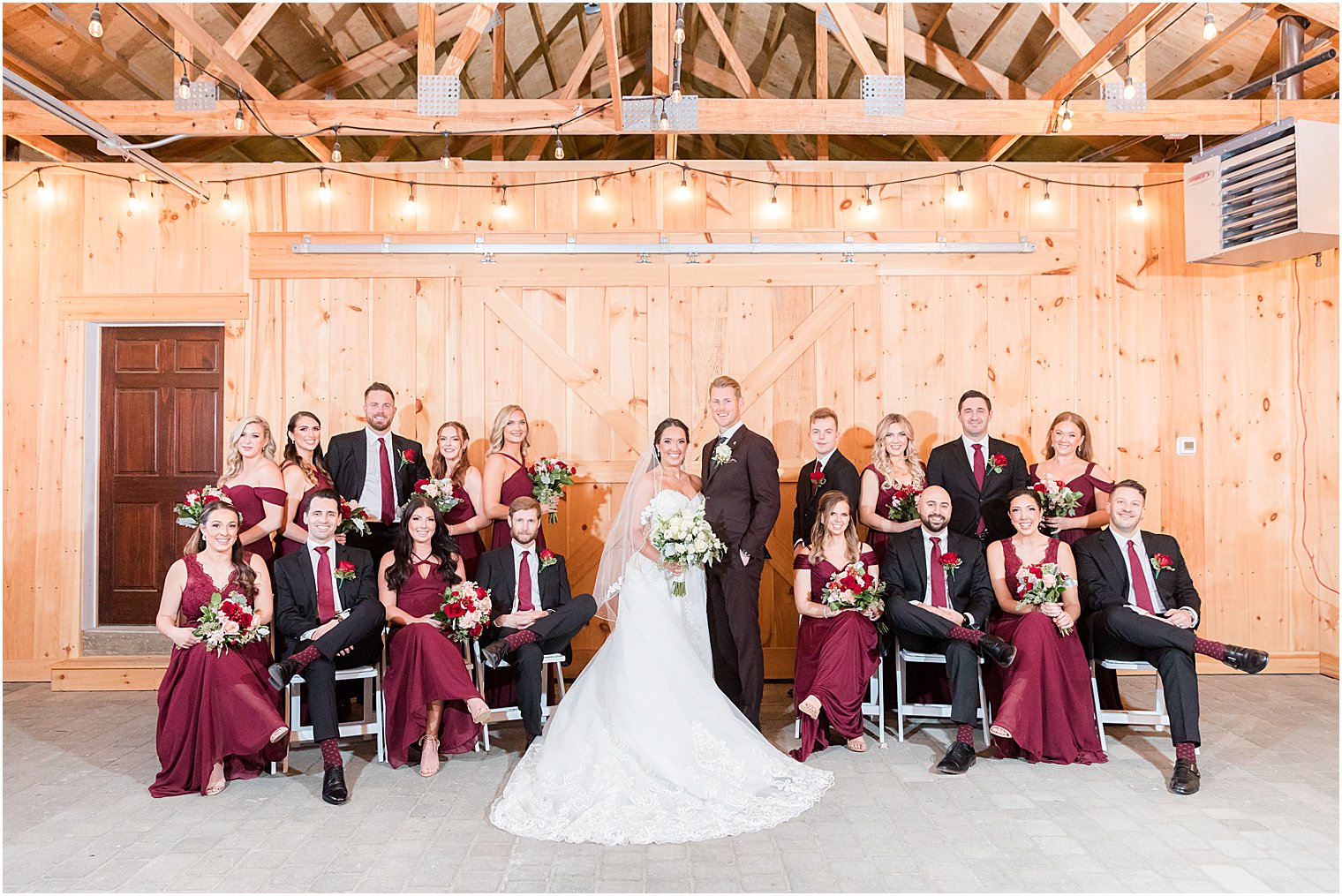 bride and groom pose with wedding party inside farmhouse