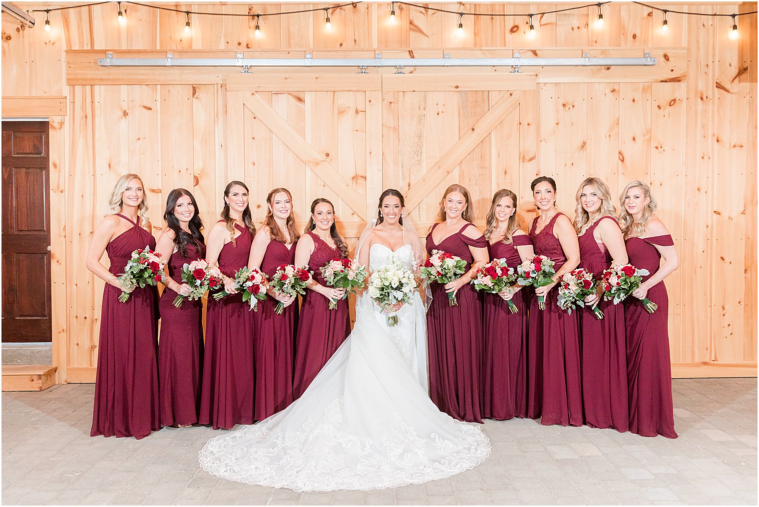 bride stands with bridesmaids in Burgundy dresses