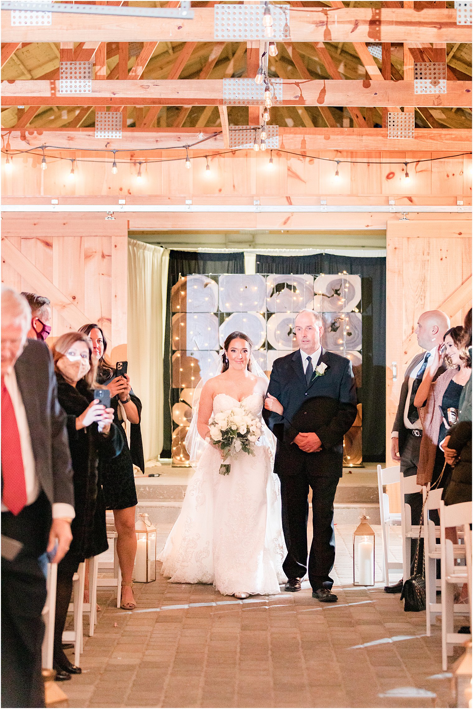 bride walks up aisle with father during farmhouse wedding ceremony at Bear Brook Valley