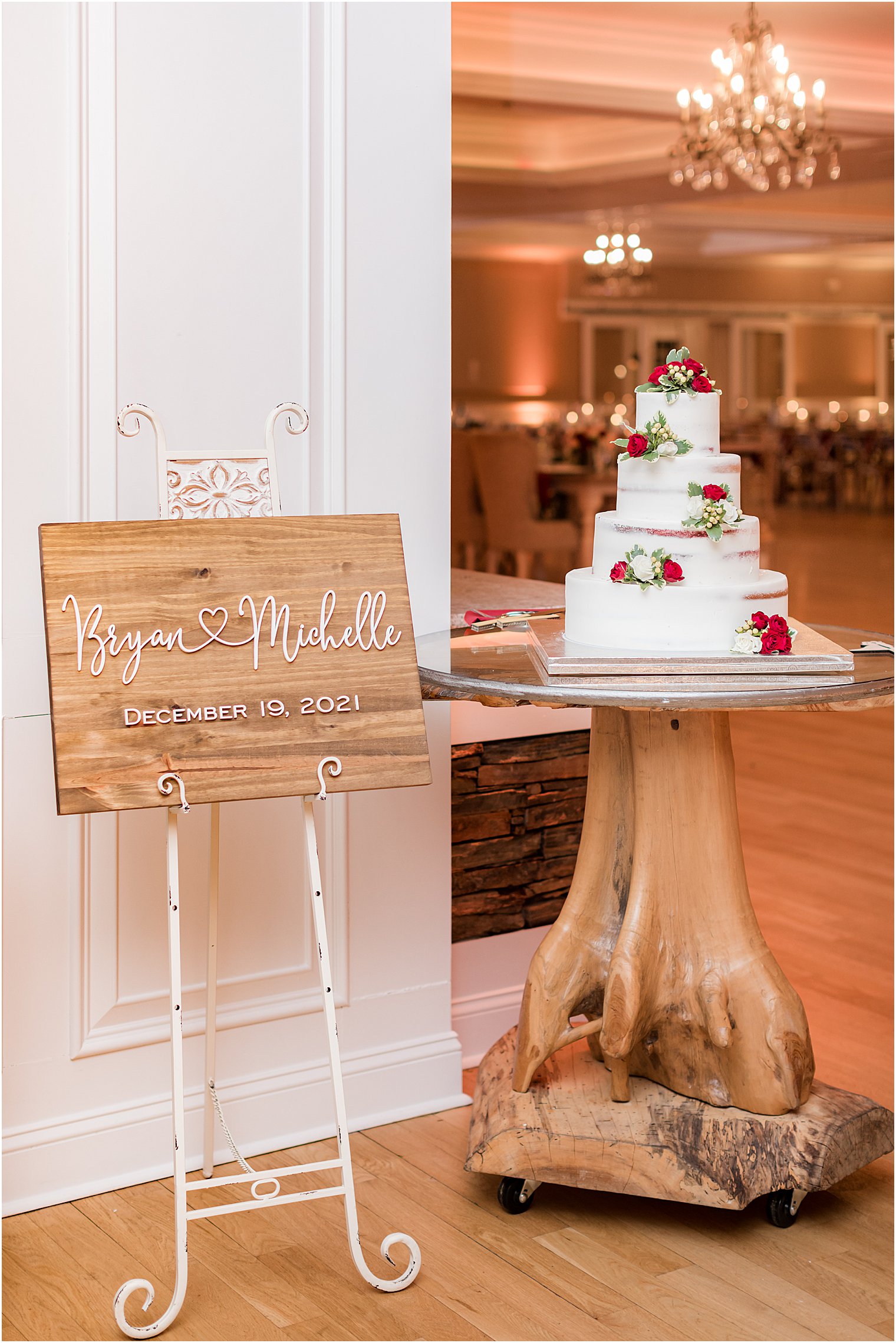 wedding sits on cake table made out of log for rustic wedding reception in New Jersey