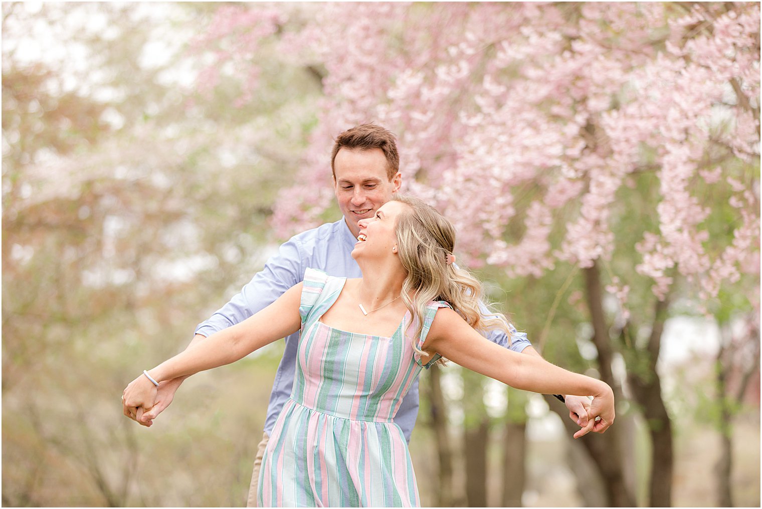 bride and groom hold their arms out looking at each other