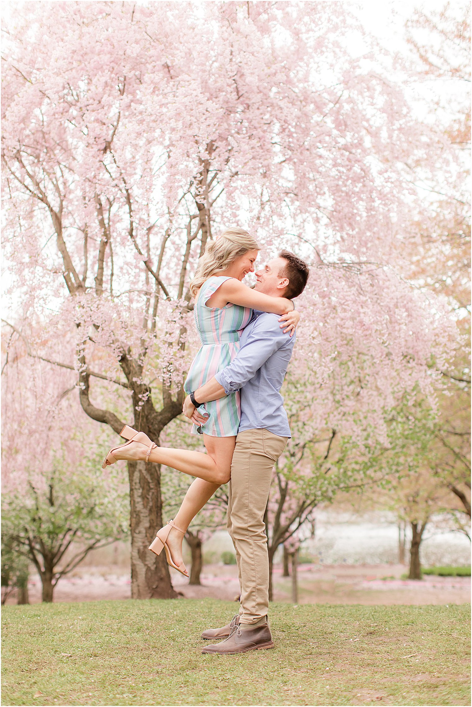 groom lifts bride during engagement session at Branch Brook Park
