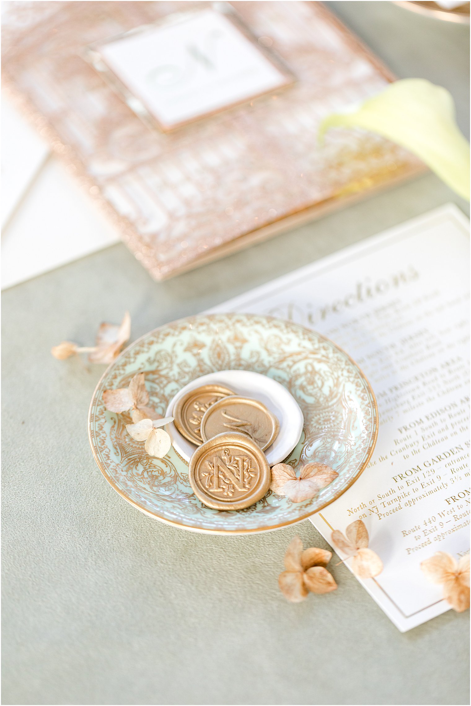 gold wax seals for invitations sit in blue and gold dish