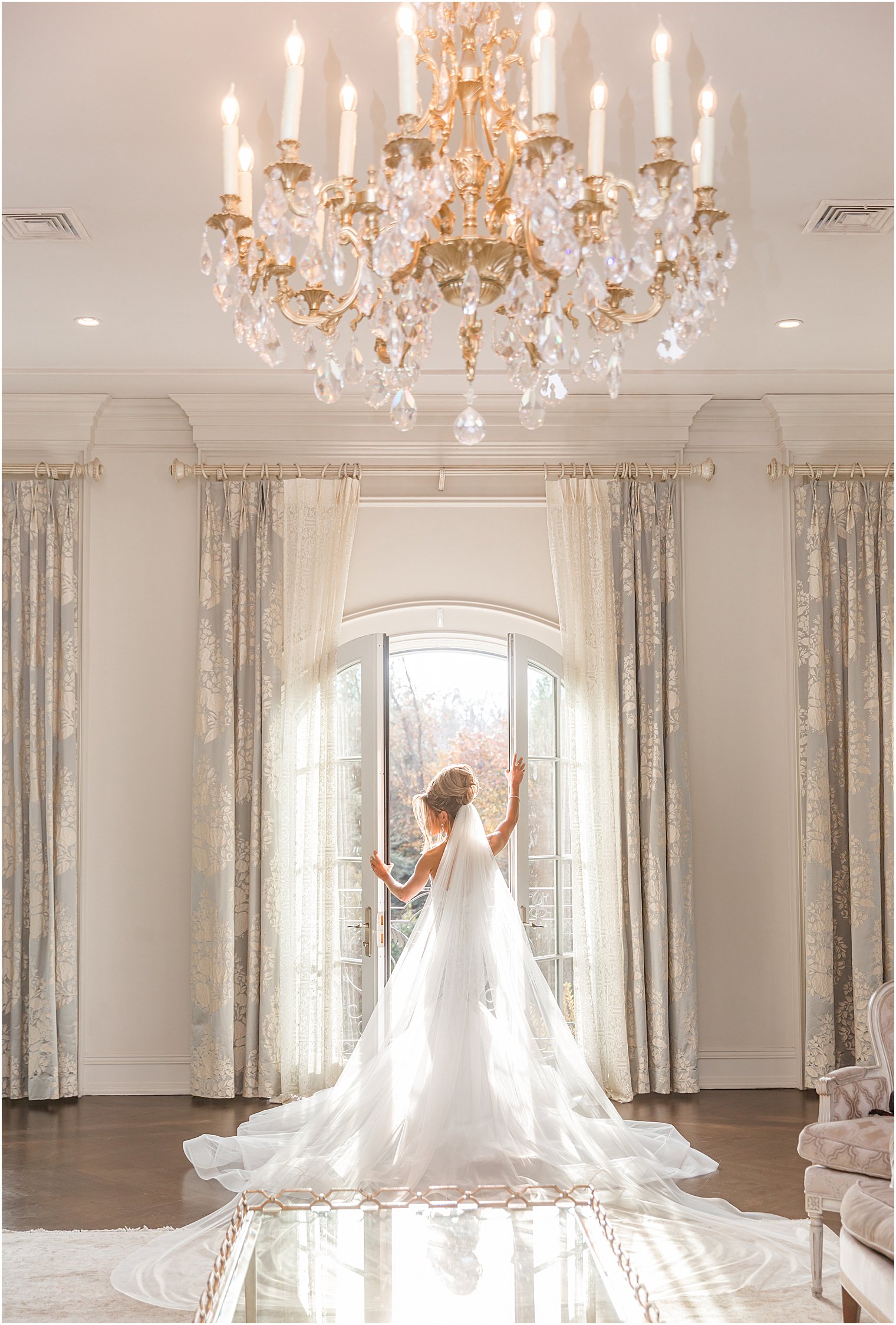 bride poses in windows of bridal suite at Park Chateau Estate 