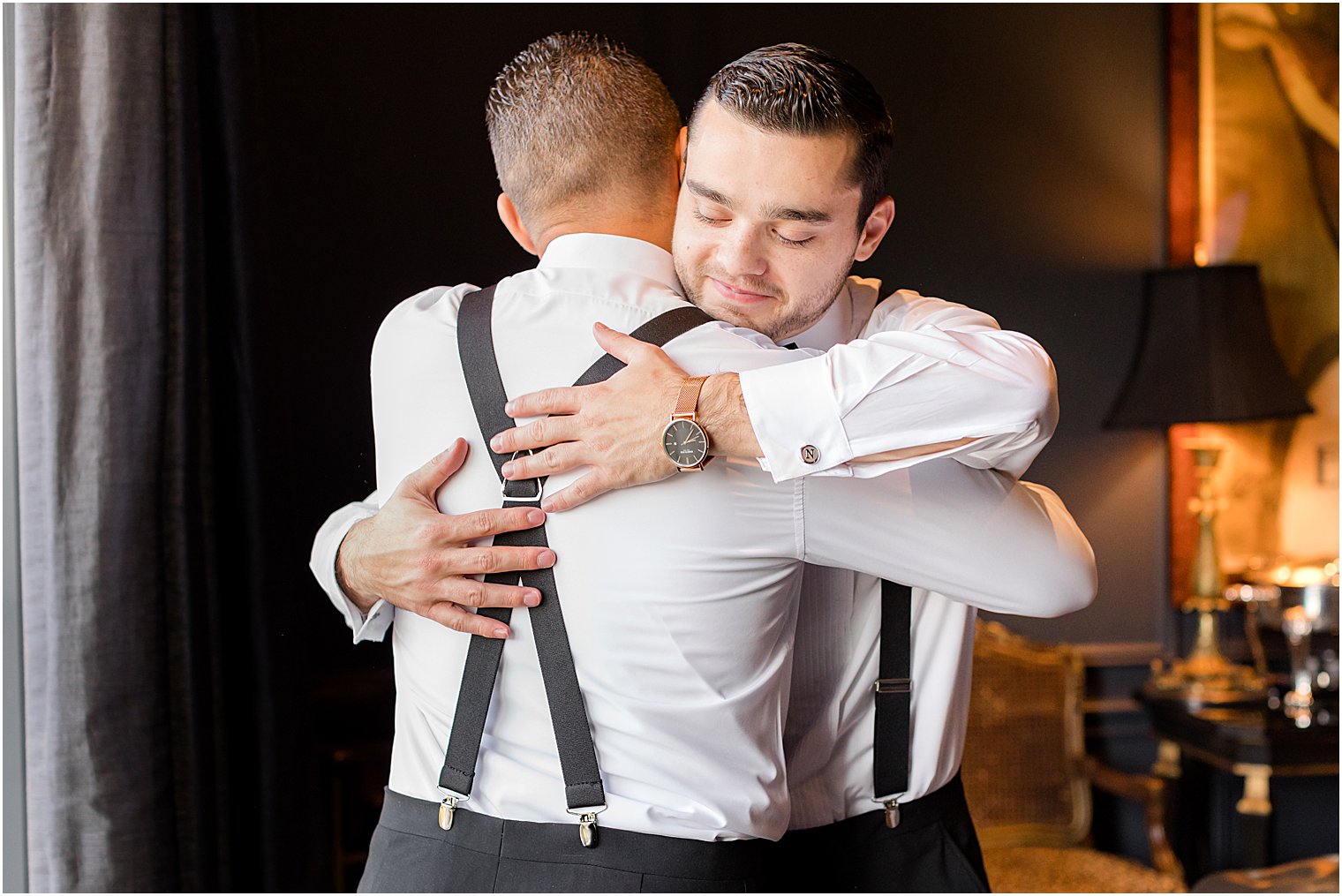 groomsman hugs groom during prep for winter Park Chateau Estate wedding