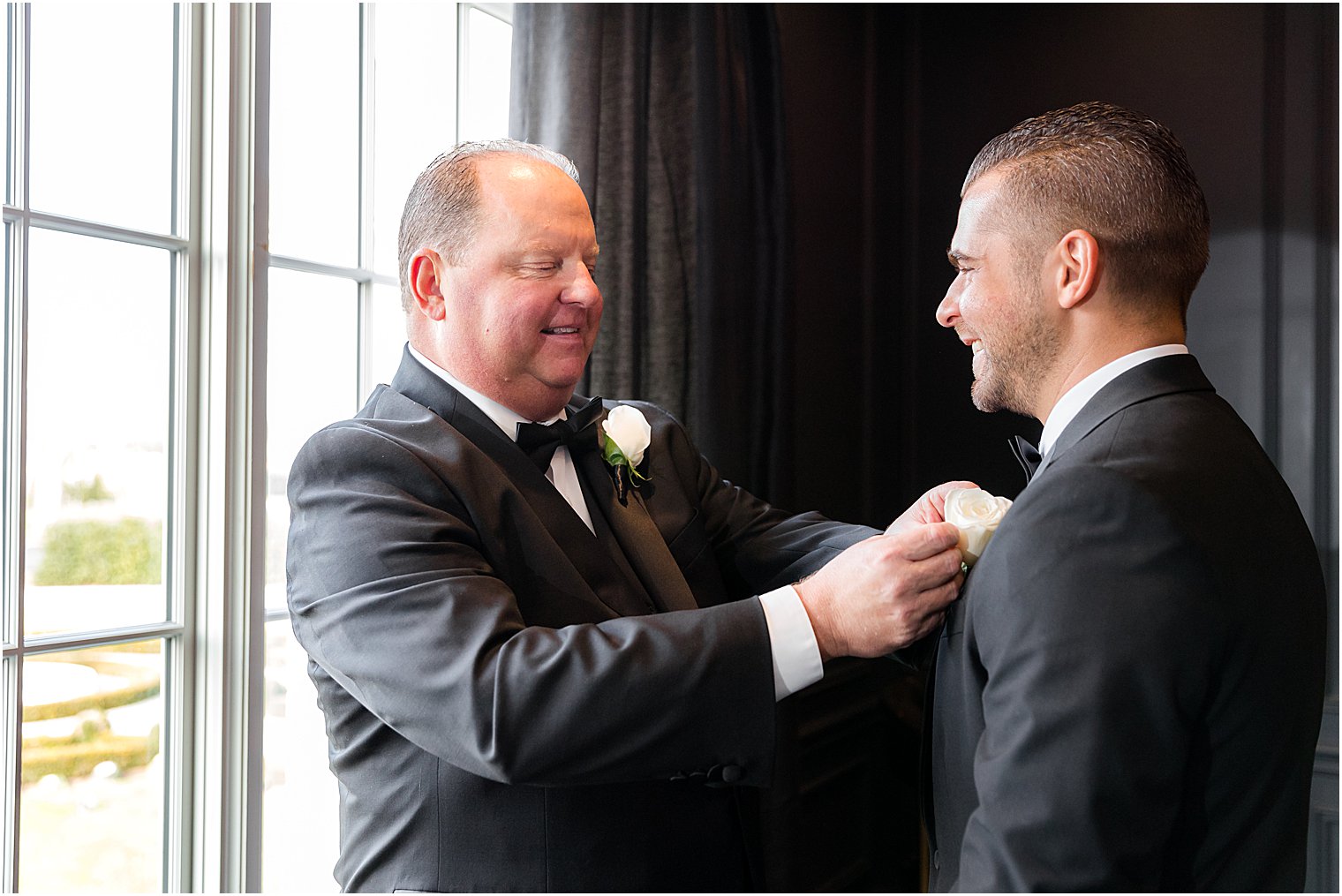 father helps groom with ivory rose boutonniere for winter wedding 