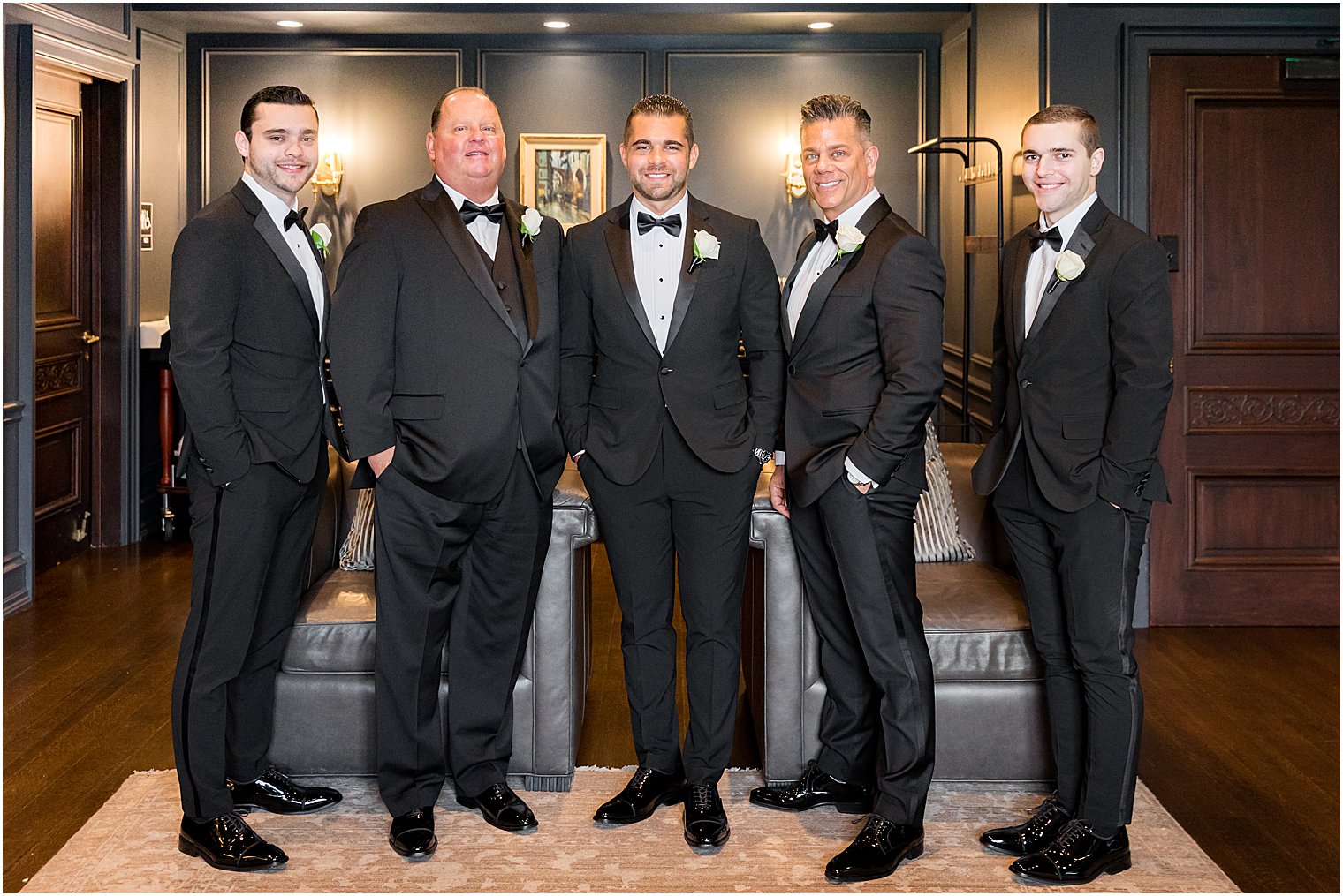groom poses with groomsmen and fathers before winter Park Chateau Estate wedding