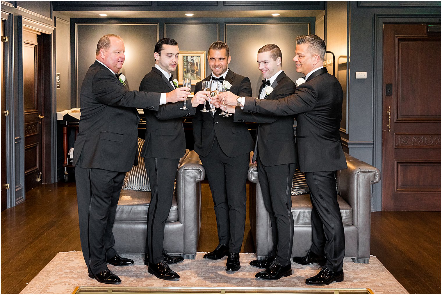 groomsmen and dads toast champagne with groom