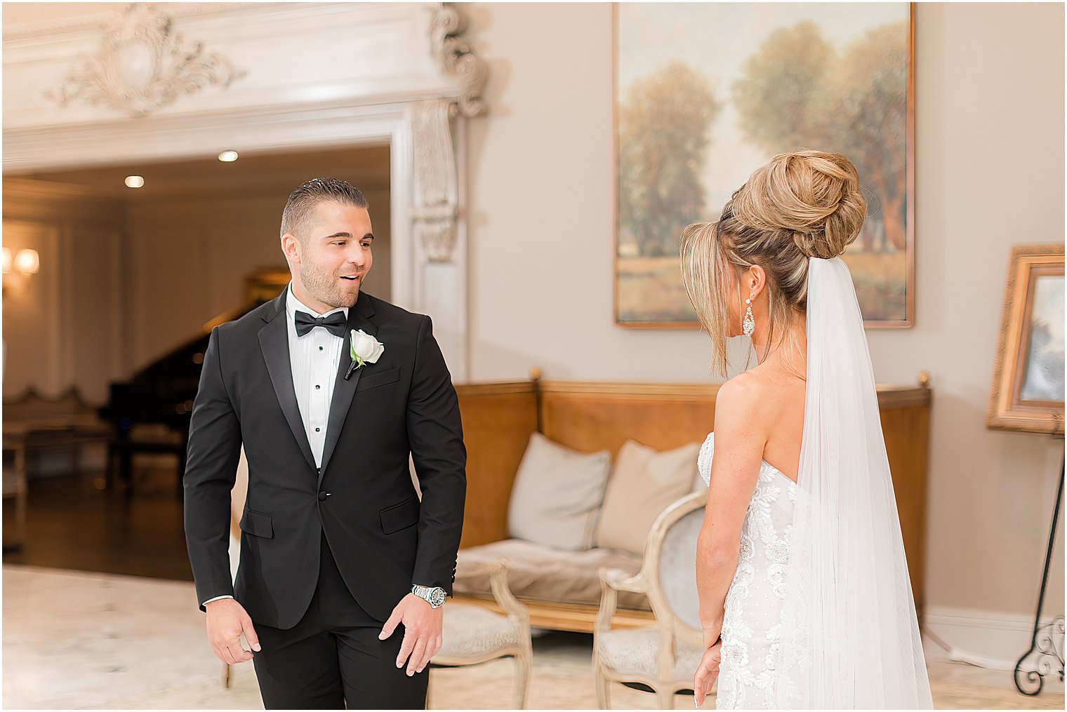 groom grins at bride during first look