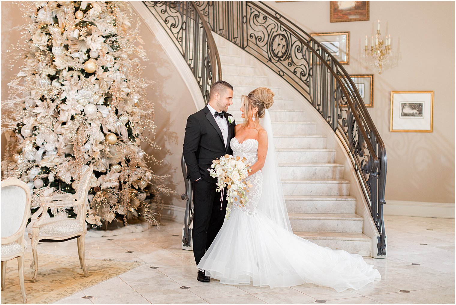 bride and groom hug at bottom of staircase in Park Chateau Estate 