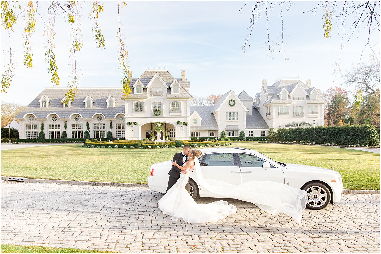 newlyweds kiss by white car before winter Park Chateau Estate wedding
