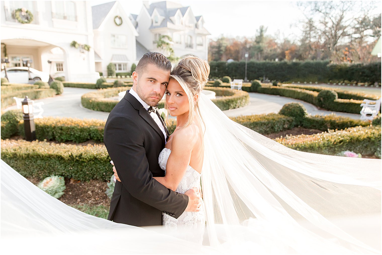 bride and groom pose with heads touching and bride's veil flared out