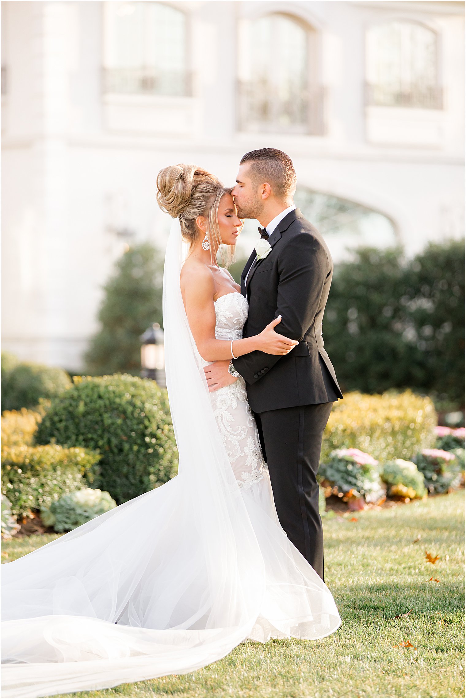 groom kisses bride's forehead during winter Park Chateau Estate wedding portraits 