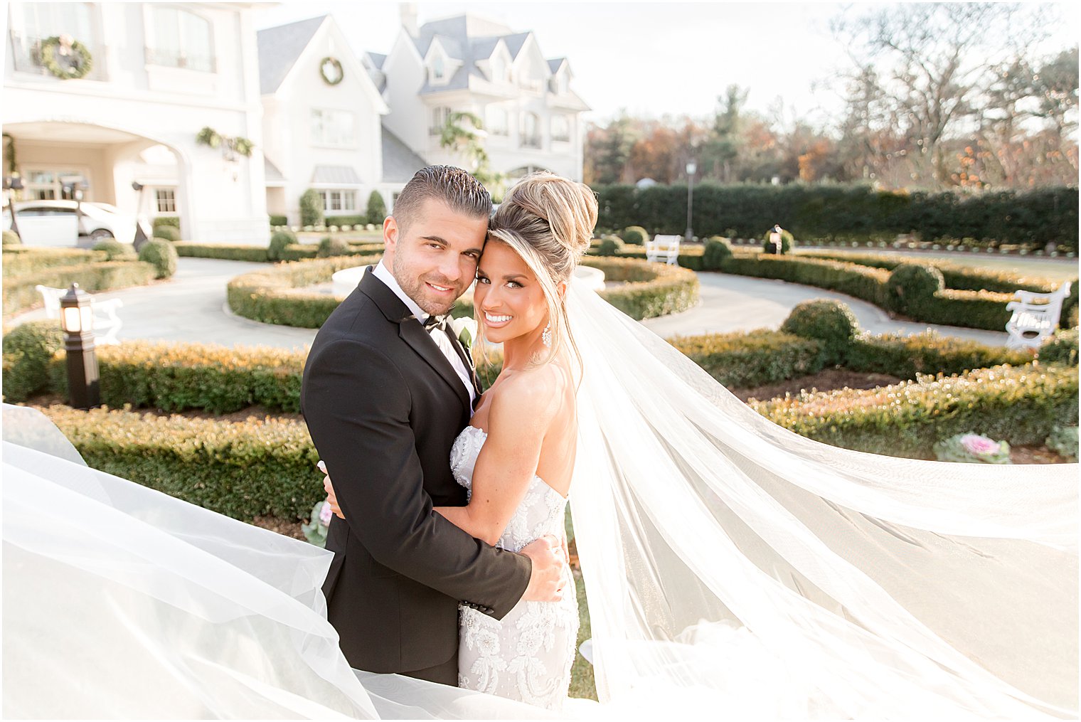 bride and groom hug with bride's veil flared out around them 