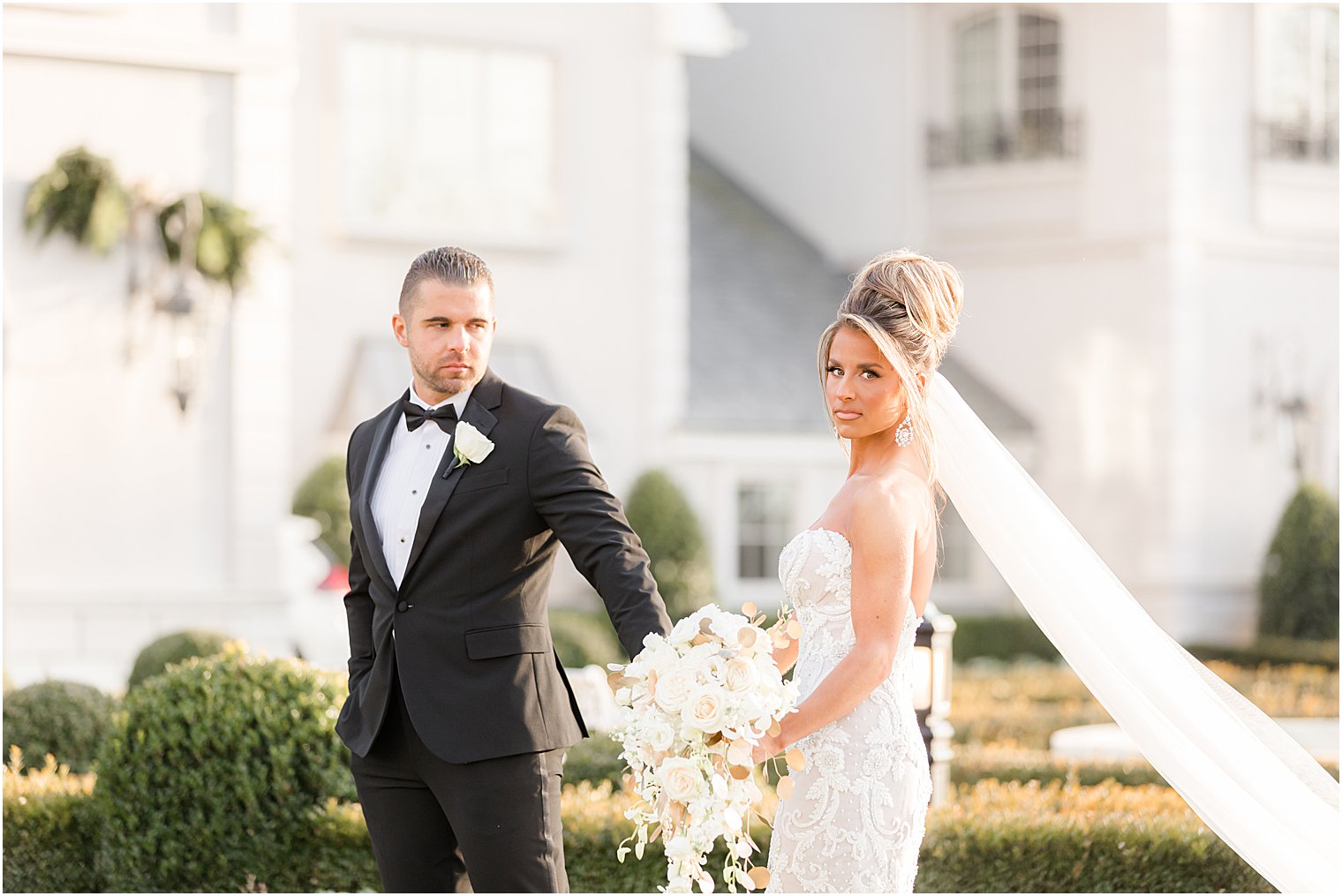 bride and groom hold hands walking through lawn at Park Chateau Estate 